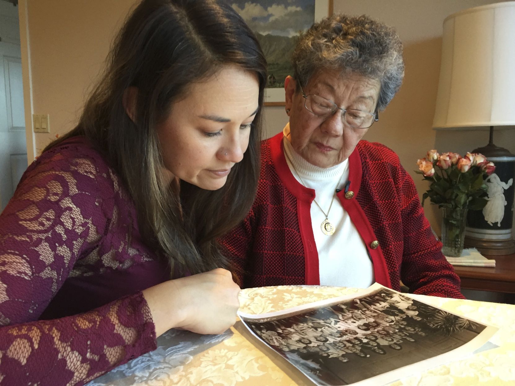 Seto and granddaughter look at a photo